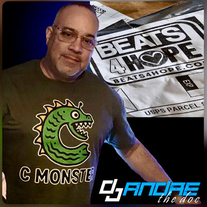 Man wearing a t-shirt with a green monster design, standing next to a 'Beats 4 Hope' poster.