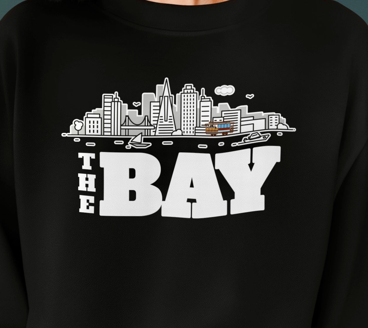 Black shirt with 'The Bay' cityscape graphic on a dark background, cable car
